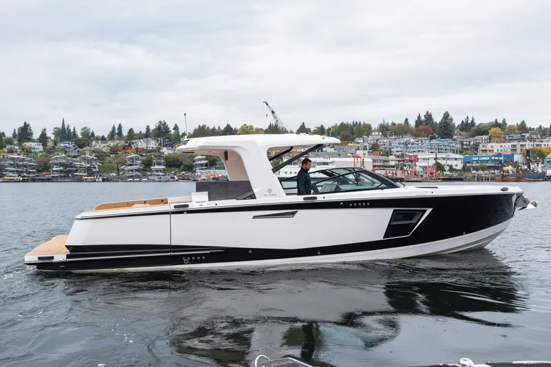  Yacht Photos Pics 2024 Aviara AV40 I/O luxury boat cruising on a scenic waterfront.