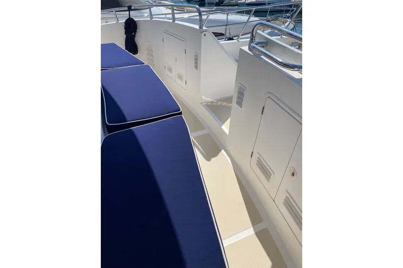  Yacht Photos Pics Deck view of 2005 Selene 47 yacht with blue cushions and white storage compartments.