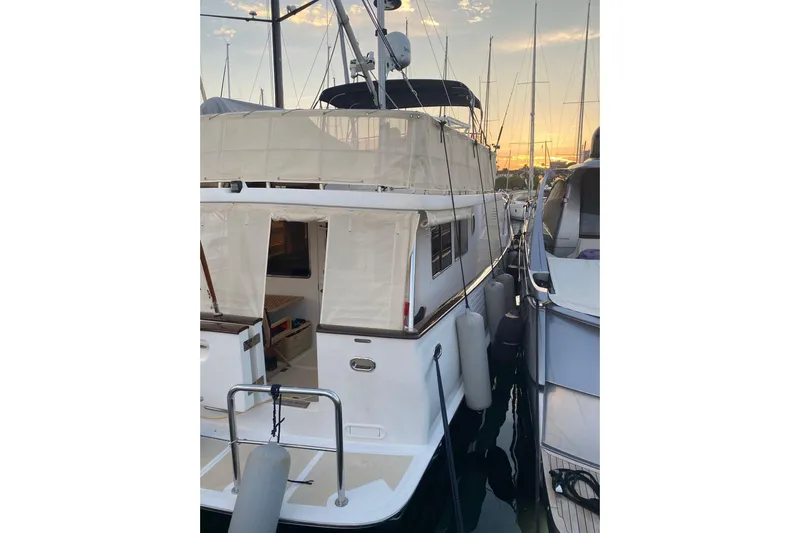  Yacht Photos Pics 2005 Selene 47 yacht docked at sunset, featuring covered deck and mooring fenders.