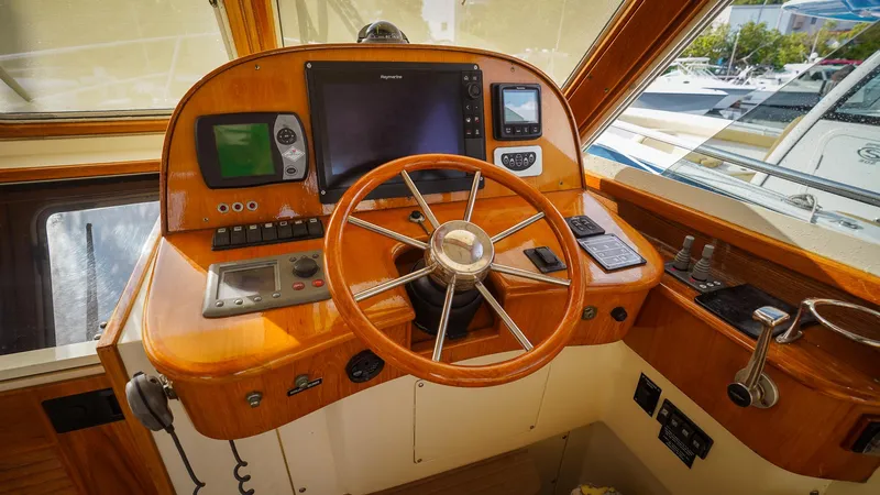 Gyspy Baby Yacht Photos Pics Wooden helm of 2007 Legacy 32 boat with navigation instruments and steering wheel.