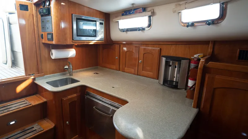 Gyspy Baby Yacht Photos Pics 2007 Legacy 32 yacht kitchen with wood cabinetry, microwave, and sink.