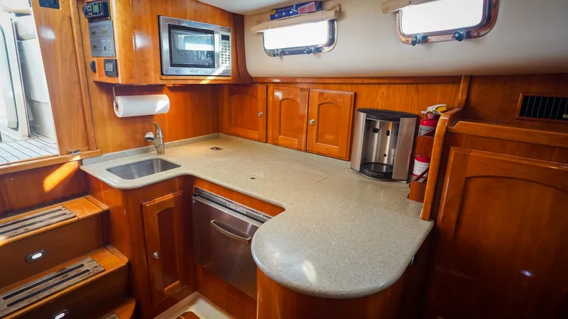 Gyspy Baby Yacht Photos Pics Luxurious 2007 Legacy 32 yacht kitchen with wood cabinetry and modern appliances.