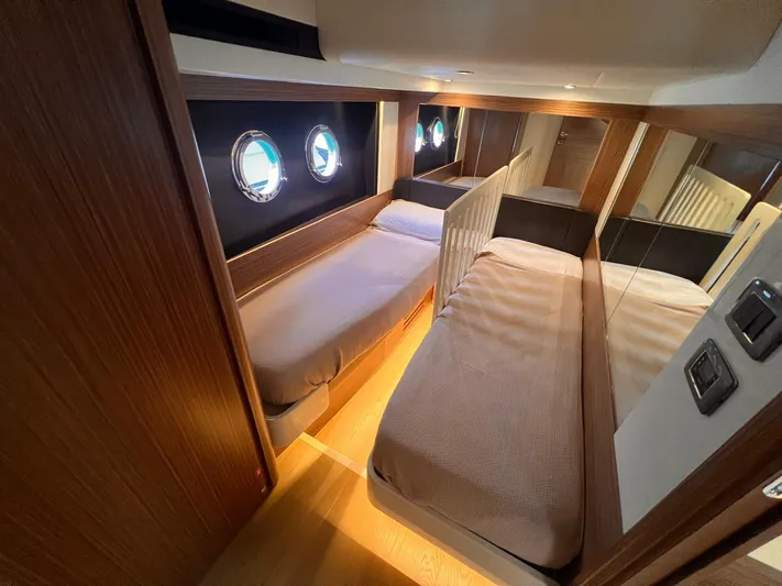  Yacht Photos Pics Interior of 2018 Absolute 52 Navetta yacht with twin beds and porthole windows.