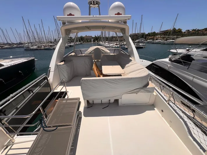  Yacht Photos Pics Luxurious 2018 Absolute 52 Navetta yacht docked in a marina, featuring spacious deck seating.