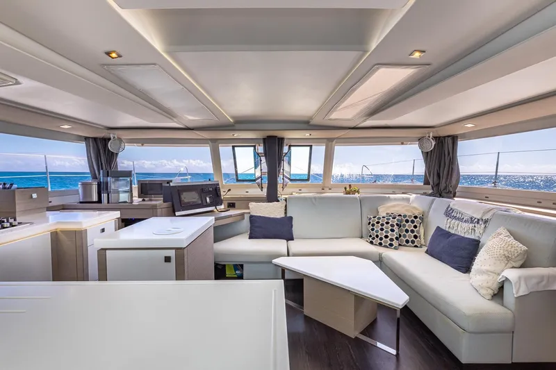 Happy Here Yacht Photos Pics Luxurious interior of 2020 Fountaine Pajot Saona 47 catamaran with modern furnishings and ocean view.