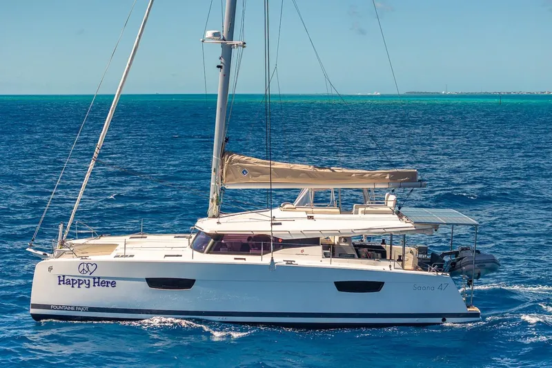 Happy Here Yacht Photos Pics 2020 Fountaine Pajot Saona 47 catamaran sailing on clear blue ocean waters.