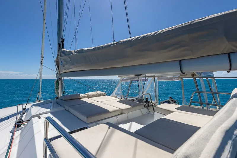 Happy Here Yacht Photos Pics 2020 Fountaine Pajot Saona 47 catamaran with sunbeds, sailing on clear blue ocean.