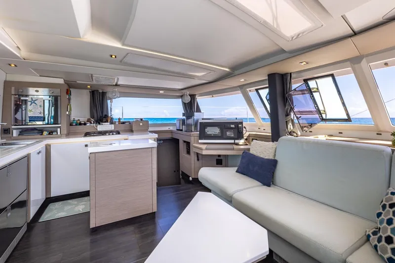 Happy Here Yacht Photos Pics Luxurious interior of 2020 Fountaine Pajot Saona 47 catamaran with modern kitchen and seating area.