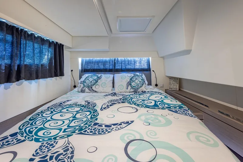Happy Here Yacht Photos Pics Luxurious cabin interior of 2020 Fountaine Pajot Saona 47 with turtle-themed bedding.