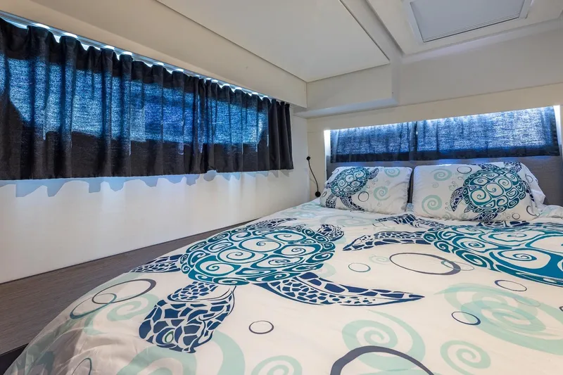 Happy Here Yacht Photos Pics Luxurious cabin interior of 2020 Fountaine Pajot Saona 47 with turtle-themed bedding.