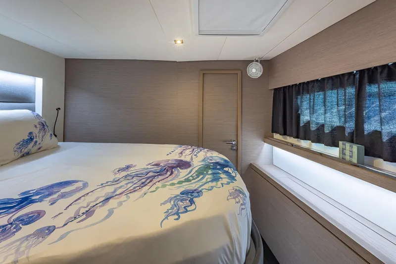 Happy Here Yacht Photos Pics Luxurious bedroom interior of 2020 Fountaine Pajot Saona 47 yacht with ocean-themed bedding.