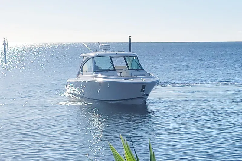  Yacht Photos Pics 2021 Pursuit DC 326 Dual Console boat cruising on calm ocean waters.