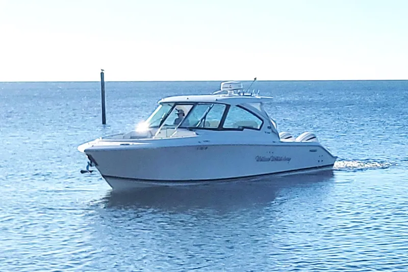  Yacht Photos Pics 2021 Pursuit DC 326 Dual Console boat cruising on calm blue waters.