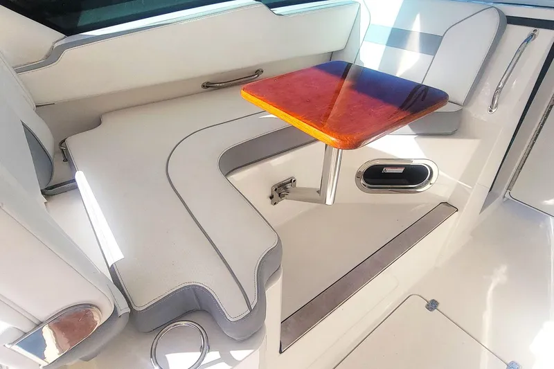  Yacht Photos Pics 2021 Pursuit DC 326 Dual Console interior with seating and wooden table.