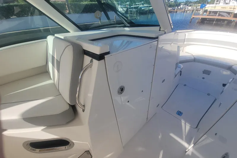  Yacht Photos Pics 2021 Pursuit DC 326 Dual Console interior with seating and storage, dockside view.