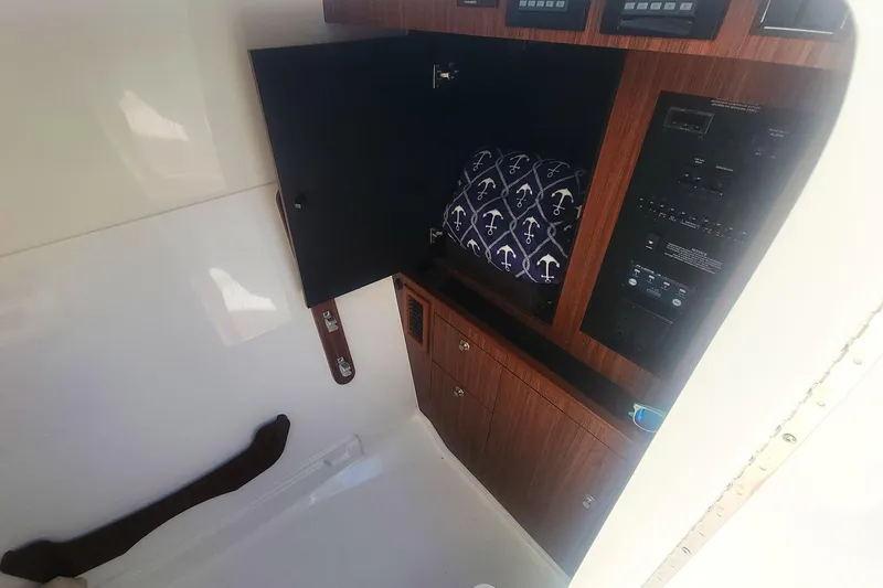  Yacht Photos Pics 2021 Pursuit DC 326 Dual Console interior with wooden cabinetry and anchor-patterned cushion.