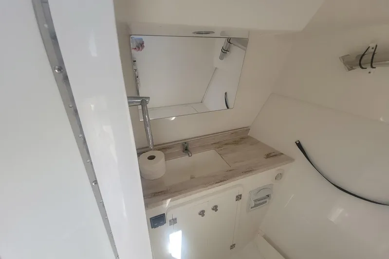  Yacht Photos Pics 2021 Pursuit DC 326 Dual Console boat bathroom with sink, mirror, and storage.