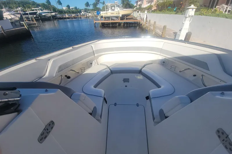  Yacht Photos Pics 2021 Pursuit DC 326 Dual Console boat interior with spacious seating in a marina setting.