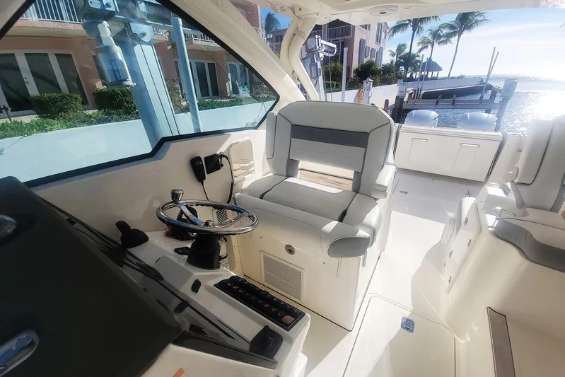  Yacht Photos Pics 2021 Pursuit DC 326 Dual Console boat interior with helm and seating, dockside view.