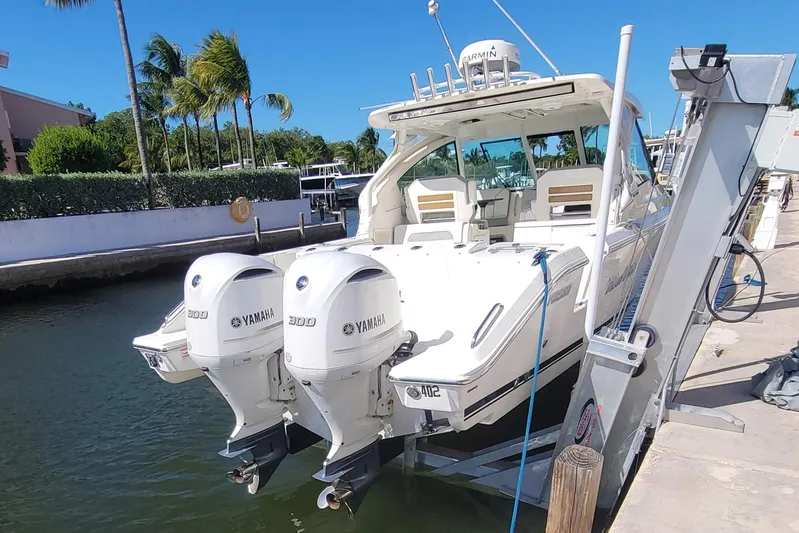  Yacht Photos Pics 2021 Pursuit DC 326 Dual Console boat with twin Yamaha engines docked by palm trees.