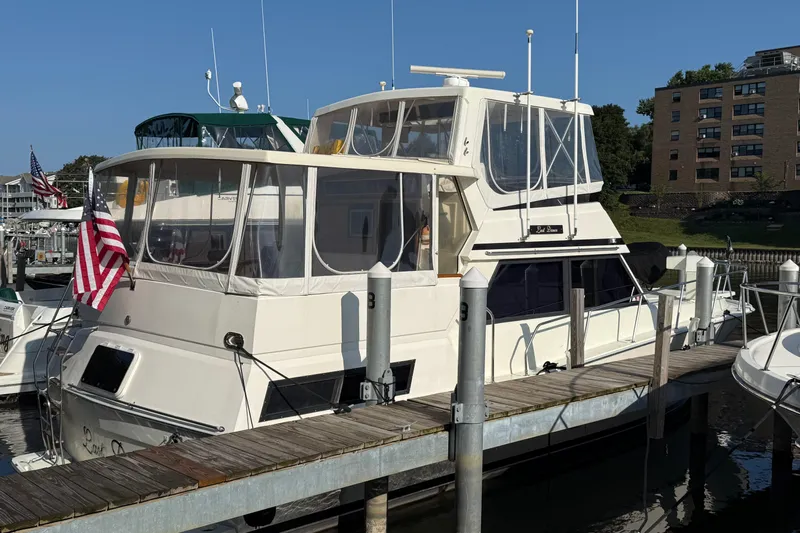 Last Dance Yacht Photos Pics 1989 Viking Boats 44 Motor Yacht docked with American flag, marina background.