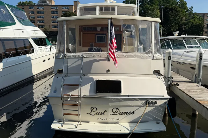 Last Dance Yacht Photos Pics 1989 Viking Boats 44 Motor Yacht docked, rear view with American flag, named "Last Dance."
