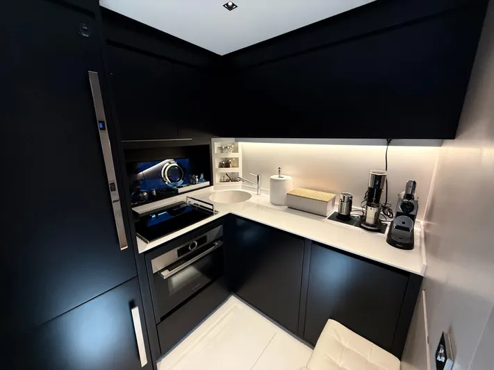 Yacht Photos Pics Modern kitchen interior on 2022 Riva 76' Perseo Super yacht, featuring sleek black cabinetry.