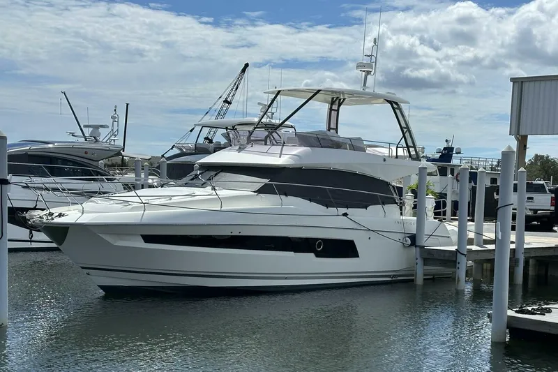 Our Trade Yacht Photos Pics 2024 Prestige 460 yacht docked at a marina under a partly cloudy sky.