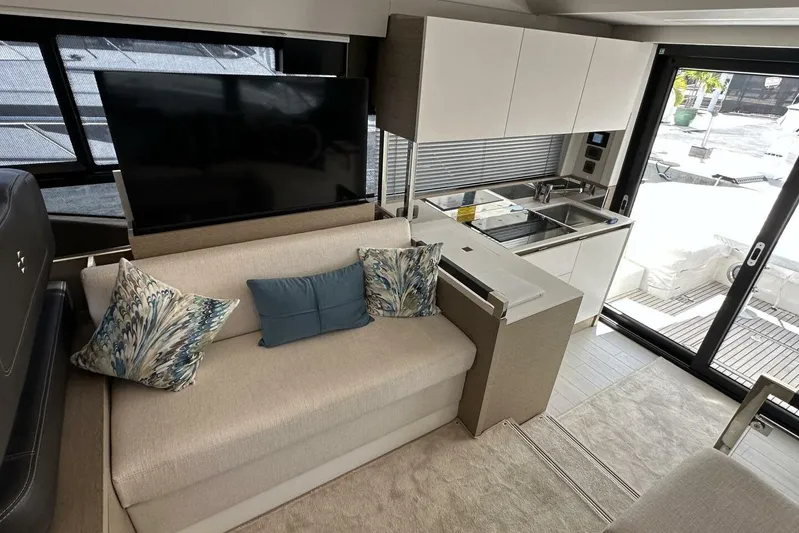 Our Trade Yacht Photos Pics Luxurious interior of 2024 Prestige 460 yacht with modern kitchen and cozy seating area.