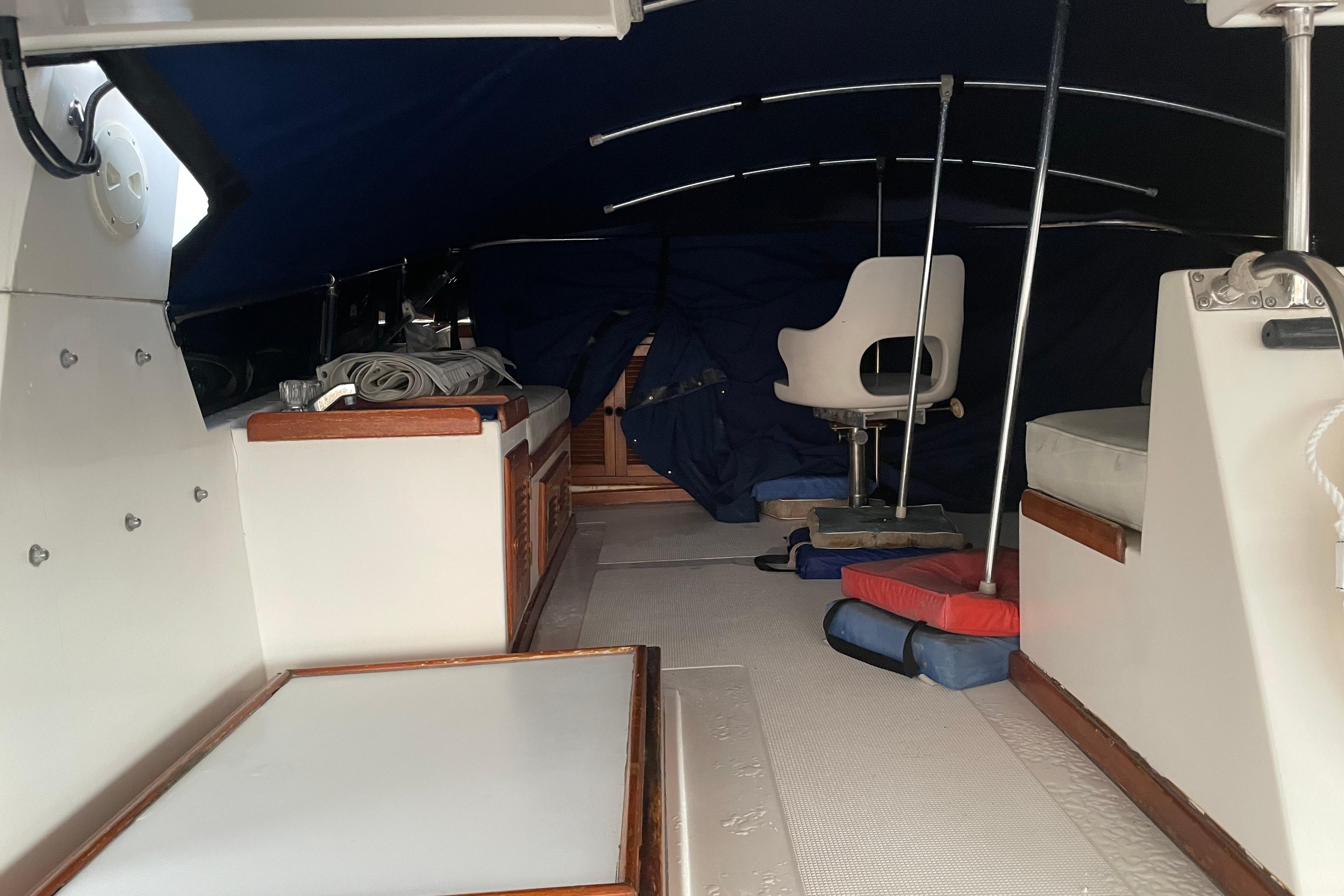 1985 Nova 40 Sundeck Aft Cabin interior with seating and storage under a blue canopy.
