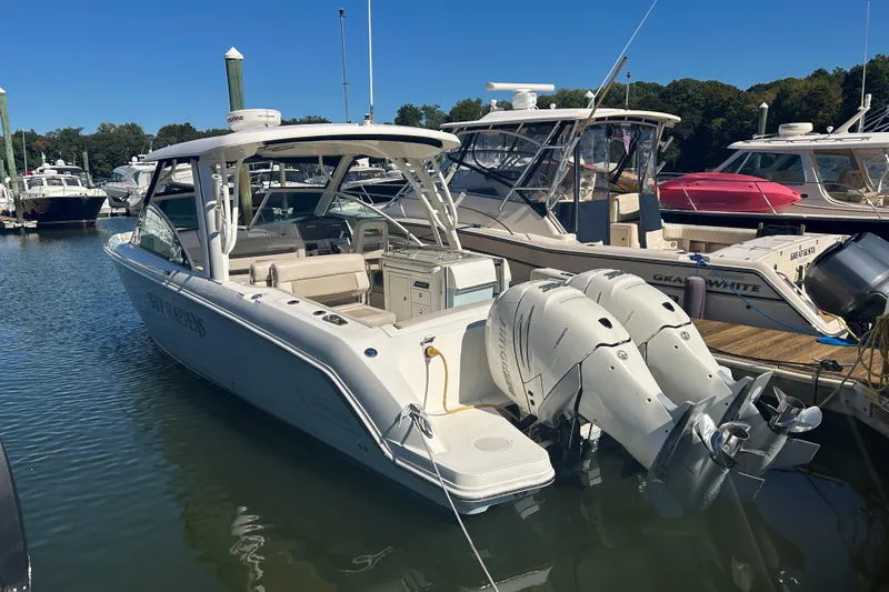 Ship Happens Yacht Photos Pics 2018 Boston Whaler 320 Vantage docked with twin engines, clear sky background.
