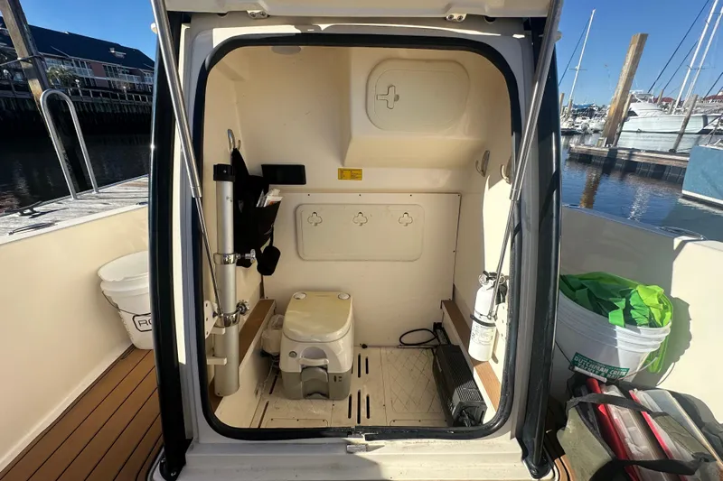 O-sea-d 2 Yacht Photos Pics 2021 Scout 251 XSS boat interior with compact toilet and storage, docked at marina.