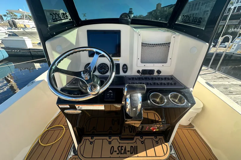 O-sea-d 2 Yacht Photos Pics 2021 Scout 251 XSS boat helm with steering wheel and control panel.