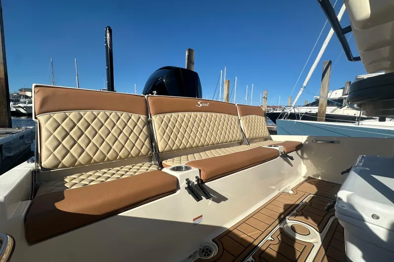 O-sea-d 2 Yacht Photos Pics 2021 Scout 251 XSS boat interior with tan quilted seating and wooden deck.