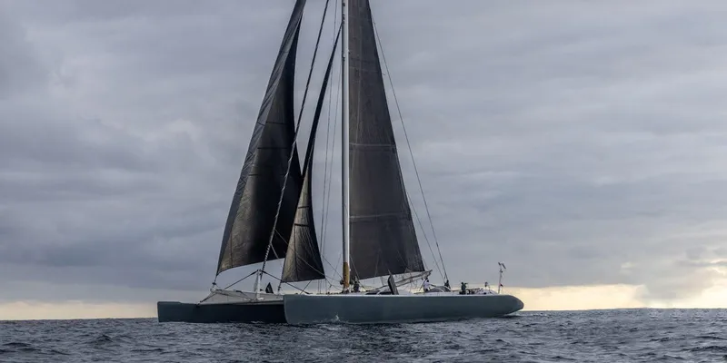 Maxicat Victoria Yacht Photos Pics A 2000 Multiplast fast cruising conversion maxi catamaran sailing on open water under cloudy skies.