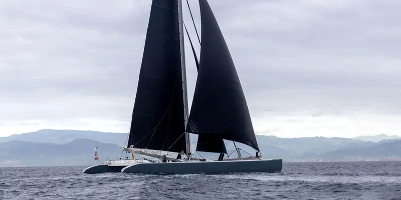 Maxicat Victoria Yacht Photos Pics Fast Cruising Conversion Maxi Catamaran sailing on open sea, overcast sky, 2000 Multiplast model.