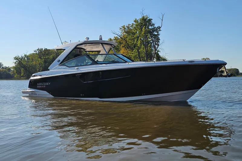  Yacht Photos Pics 2022 Monterey 378SS Super Sport boat on calm water, surrounded by trees.