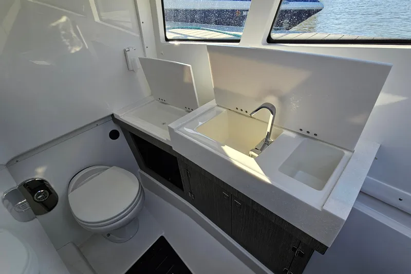  Yacht Photos Pics 2022 Monterey 378SS Super Sport boat bathroom with sink and toilet, featuring modern design.