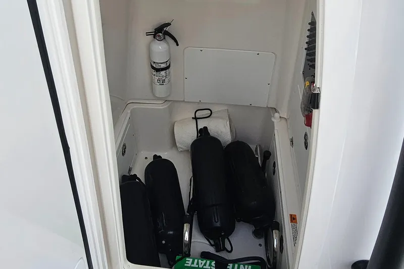  Yacht Photos Pics Storage compartment in 2023 Caymas 28 HB Twin boat with fire extinguisher and fenders.
