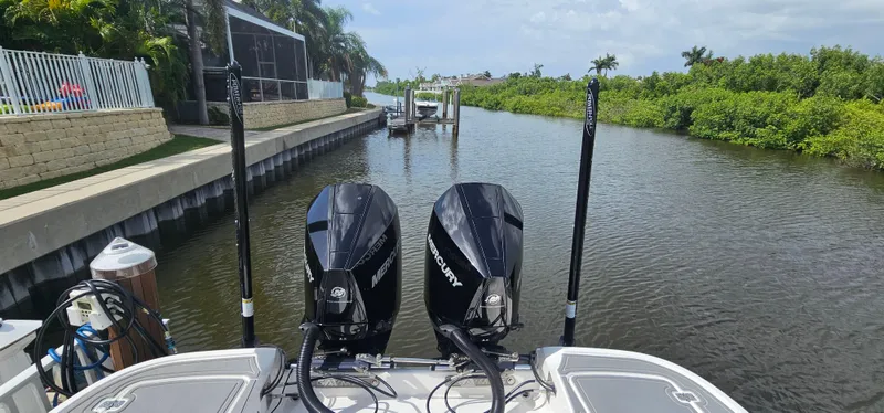  Yacht Photos Pics 2023 Caymas 28 HB Twin boat with dual Mercury engines docked by a canal.
