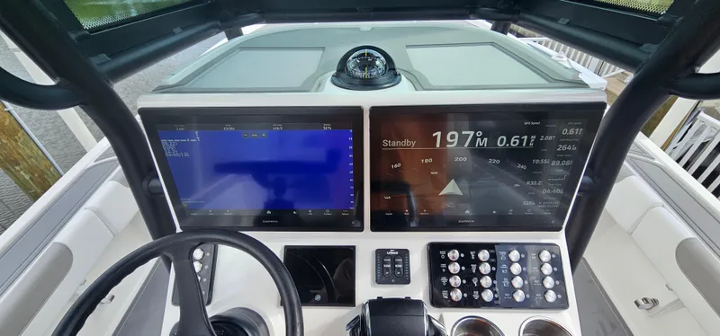  Yacht Photos Pics 2023 Caymas 28 HB Twin boat dashboard with dual Garmin displays and steering wheel.