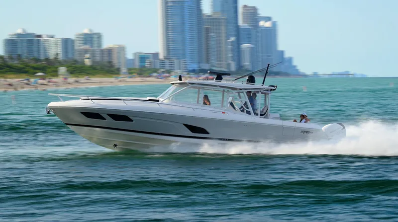  Yacht Photos Pics 2021 Intrepid 409 Valor cruising near city skyline on open water.
