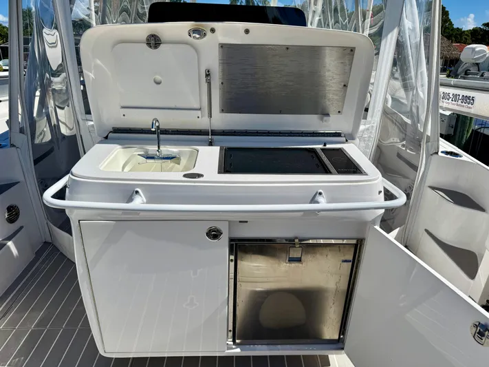  Yacht Photos Pics 2021 Intrepid 409 Valor boat kitchenette with sink, grill, and storage.