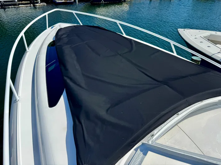  Yacht Photos Pics 2021 Intrepid 409 Valor boat with black cover on deck, docked in marina.