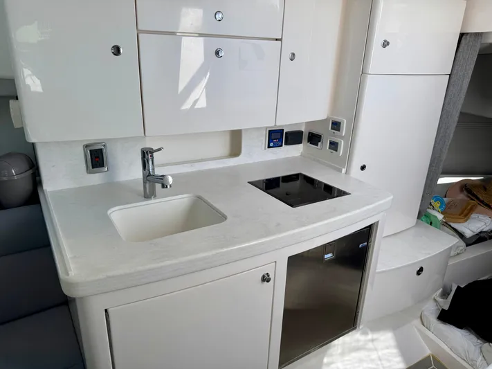  Yacht Photos Pics 2021 Intrepid 409 Valor yacht kitchen with sink, stove, and storage cabinets.