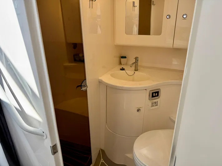  Yacht Photos Pics 2021 Intrepid 409 Valor boat bathroom with sink, mirror, and toilet.