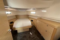 Cabin interior of 2020 Fjord 40 Open yacht with bed and wooden cabinetry.