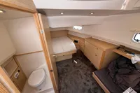 Cabin interior of 2020 Fjord 40 Open yacht, featuring bed, storage, and compact bathroom.