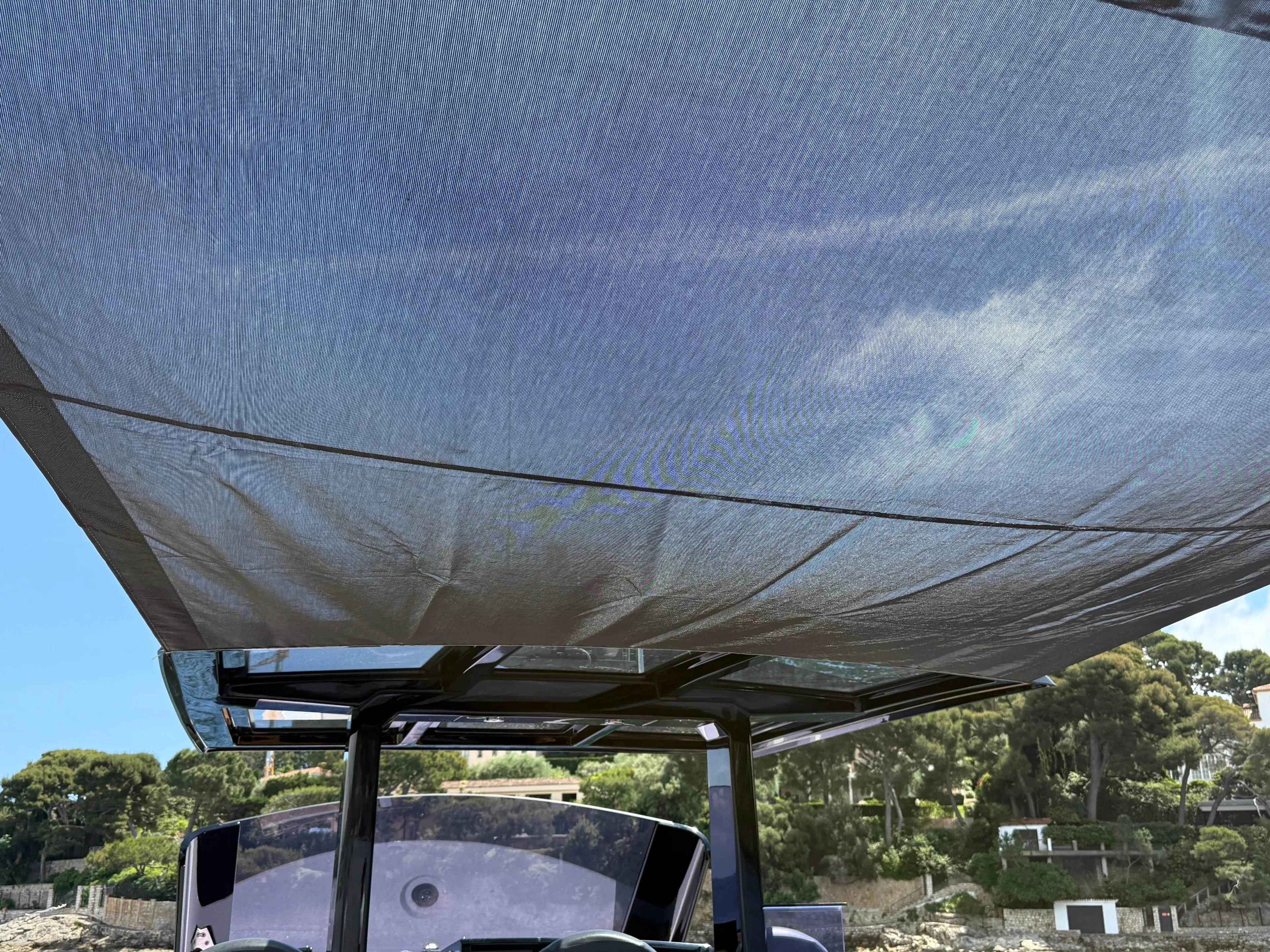 Fjord 40 Open 2020 boat with canopy, scenic background, clear sky.
