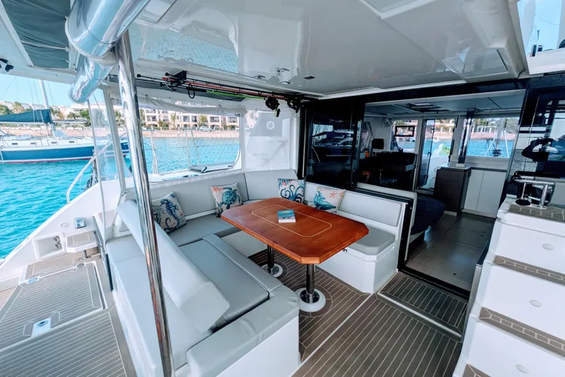 Momentum 42 Yacht Photos Pics Luxurious 2023 Leopard 42 yacht interior with elegant seating and wooden table, docked by the sea.